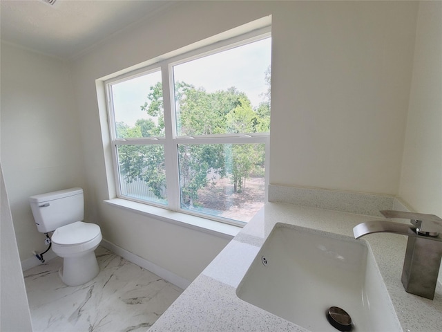 9926 Tangiers Rd, Houston, TX 77041 - bathroom with a sink, healthy amount of natural light, toilet, marble look tile flooring, and crown molding