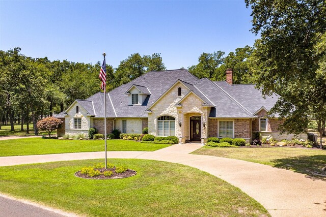 167 Saint Andrews Dr E, Mabank, TX 75156 - french country style house featuring stone siding, a front lawn, and a chimney