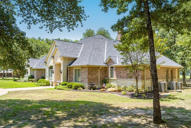 167 Saint Andrews Dr E, Mabank, TX 75156 - view of front of home featuring central AC, a front lawn, brick siding, and stone siding