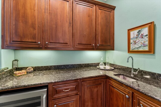 167 Saint Andrews Dr E, Mabank, TX 75156 - kitchen with beverage cooler, a sink, and dark stone countertops