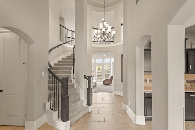 17006 Shannon Lake Ct, Houston, TX 77044 - foyer entrance with arched walkways, stairway, baseboards, a high ceiling, and a chandelier