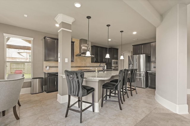 17006 Shannon Lake Ct, Houston, TX 77044 - kitchen with wall chimney range hood, appliances with stainless steel finishes, backsplash, a kitchen island with sink, and light stone counters