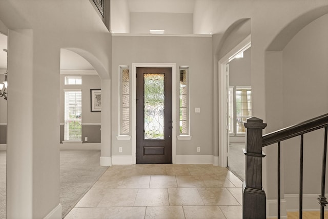 17006 Shannon Lake Ct, Houston, TX 77044 - foyer entrance featuring carpet, baseboards, arched walkways, a towering ceiling, and stairs