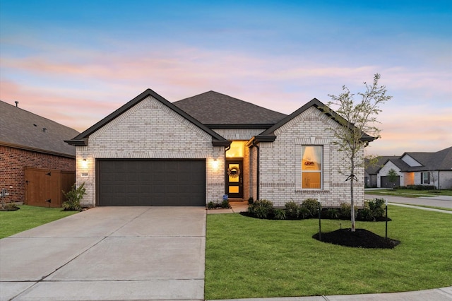 21119 Kanaka Dr, Cypress, TX 77433 - french country style house with an attached garage, driveway, a front yard, brick siding, and roof with shingles