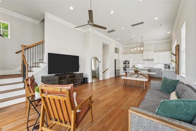 10756 Craighead Dr, Houston, TX 77025 - living area featuring recessed lighting, light wood-style floors, a ceiling fan, stairway, and ornamental molding