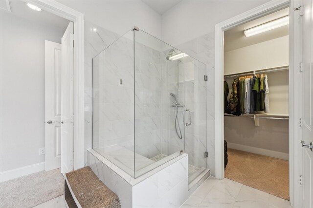 10756 Craighead Dr, Houston, TX 77025 - full bathroom featuring a walk in closet, a marble finish shower, baseboards, and marble look tiles