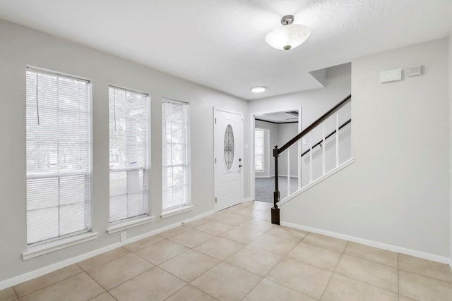 2102 Silver Moon Trl, Crosby, TX 77532 - entryway featuring baseboards, light tile patterned floors, and stairway