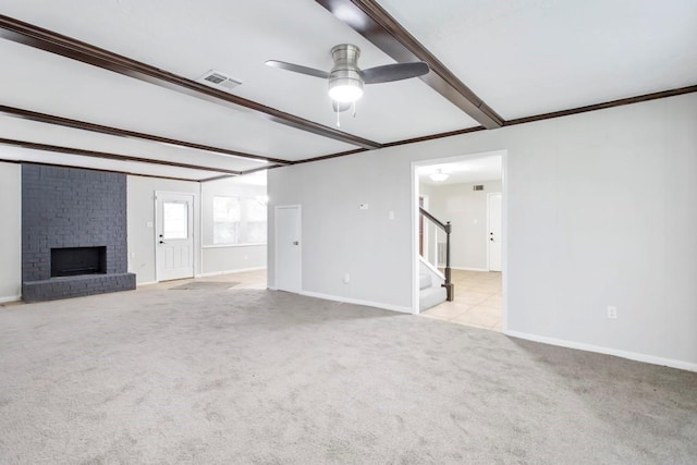 2102 Silver Moon Trl, Crosby, TX 77532 - unfurnished living room featuring stairs, beam ceiling, a brick fireplace, ceiling fan, and carpet