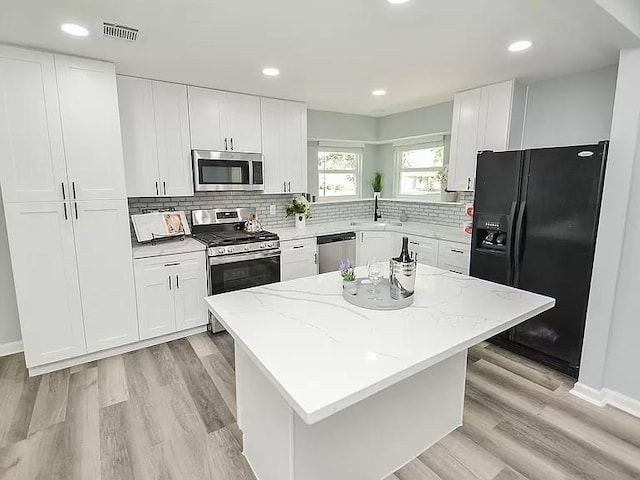 1919 Fall Meadow Dr, Missouri City, TX 77459 - kitchen featuring appliances with stainless steel finishes, a sink, a center island, decorative backsplash, and recessed lighting