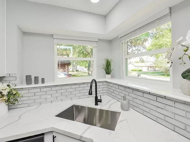 1919 Fall Meadow Dr, Missouri City, TX 77459 - kitchen with a sink, light stone counters, tasteful backsplash, and white cabinetry