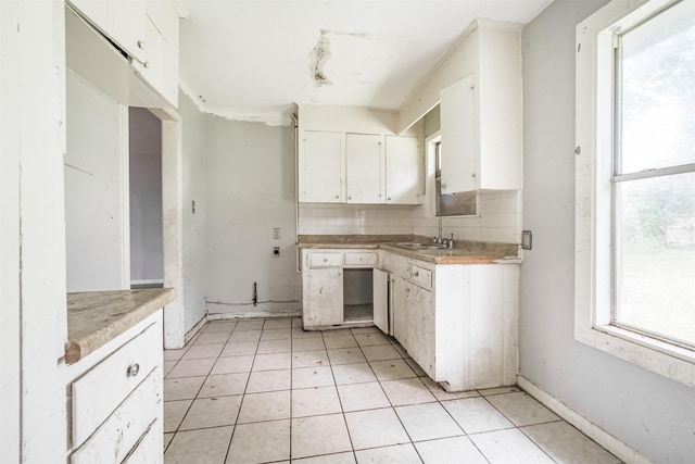 606 Roosevelt St, La Marque, TX 77568 - kitchen featuring white cabinetry, a sink, light countertops, tasteful backsplash, and light tile patterned flooring