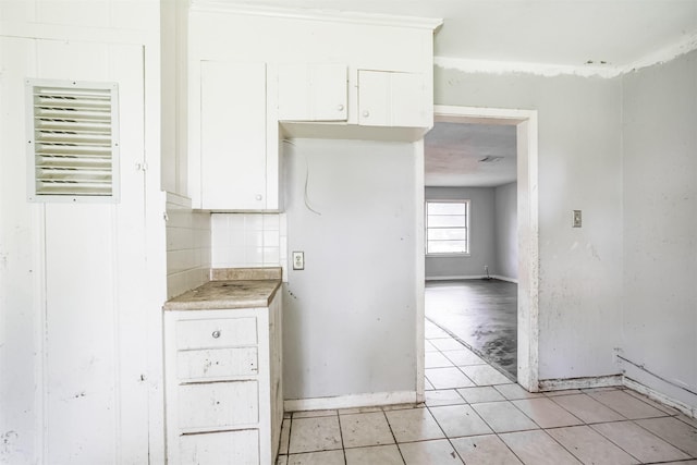 606 Roosevelt St, La Marque, TX 77568 - kitchen with white cabinetry, light tile patterned flooring, decorative backsplash, baseboards, and light countertops