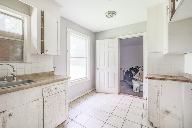 606 Roosevelt St, La Marque, TX 77568 - kitchen with a sink, backsplash, white cabinets, light tile patterned flooring, and light countertops