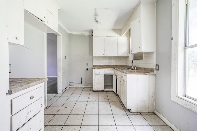 606 Roosevelt St, La Marque, TX 77568 - kitchen featuring a sink, white cabinetry, backsplash, and healthy amount of natural light