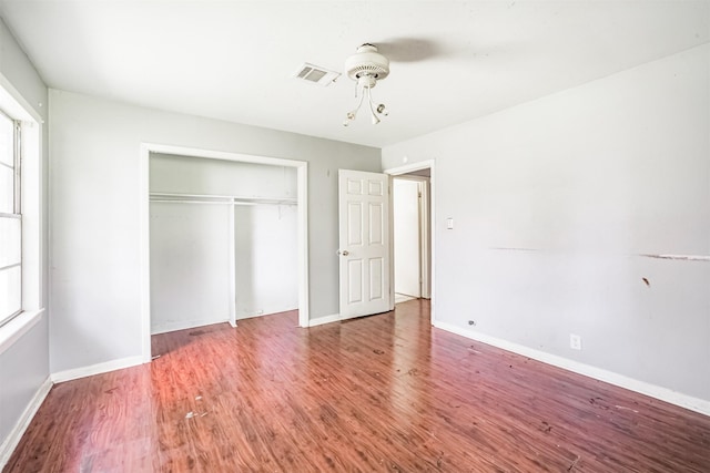 606 Roosevelt St, La Marque, TX 77568 - unfurnished bedroom with wood finished floors, a closet, multiple windows, and baseboards