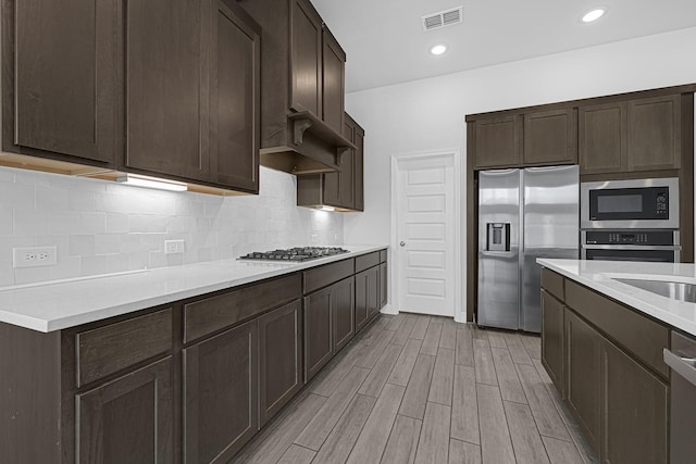 24634 Carleton Lake Ln, Tomball, TX 77375 - kitchen with appliances with stainless steel finishes, dark brown cabinets, and light countertops