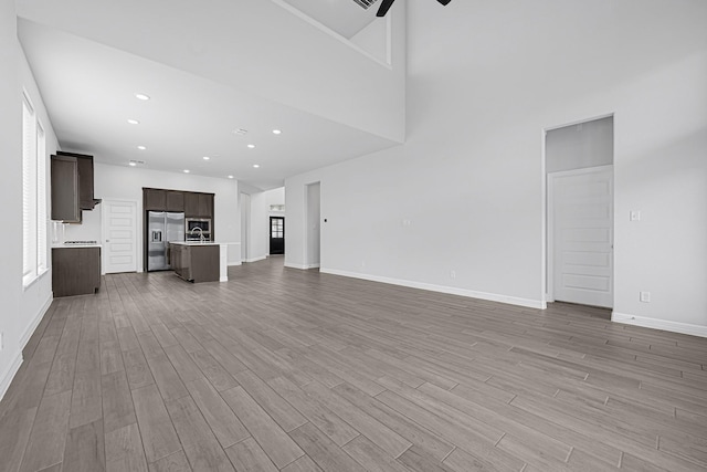 24634 Carleton Lake Ln, Tomball, TX 77375 - unfurnished living room featuring light wood-style floors, baseboards, ceiling fan, a sink, and recessed lighting