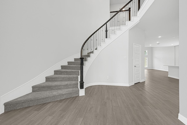 24634 Carleton Lake Ln, Tomball, TX 77375 - staircase with wood finished floors, baseboards, recessed lighting, and a high ceiling