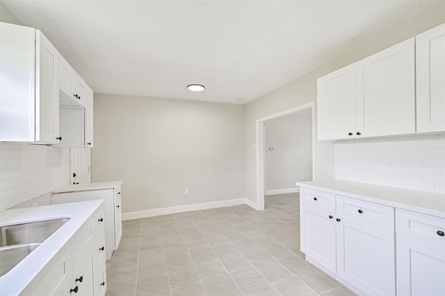 5007 Northridge Dr, Houston, TX 77033 - kitchen with tasteful backsplash, light countertops, white cabinets, a sink, and baseboards