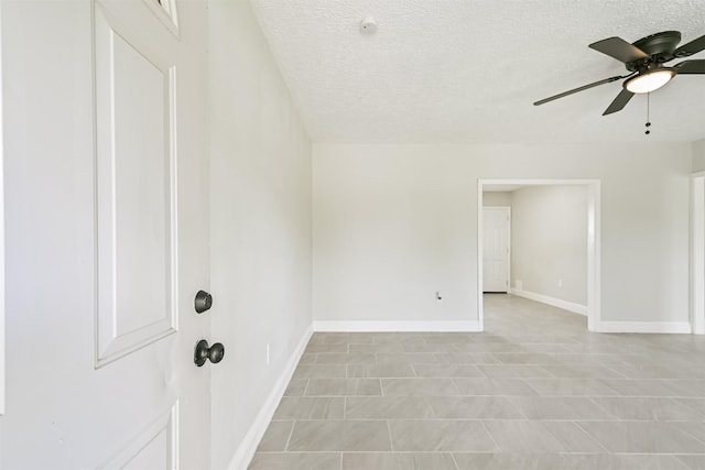 5007 Northridge Dr, Houston, TX 77033 - empty room with ceiling fan, a textured ceiling, baseboards, and tile patterned flooring
