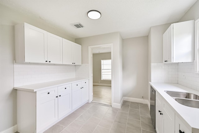 5007 Northridge Dr, Houston, TX 77033 - kitchen with light countertops, white cabinets, backsplash, and a textured ceiling