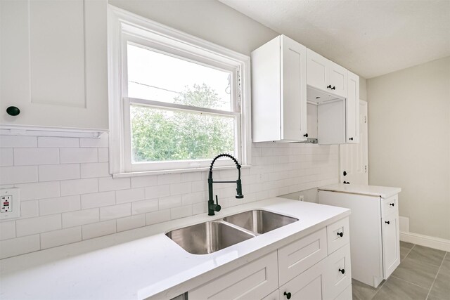 5007 Northridge Dr, Houston, TX 77033 - kitchen with a sink, white cabinets, light countertops, light tile patterned floors, and tasteful backsplash