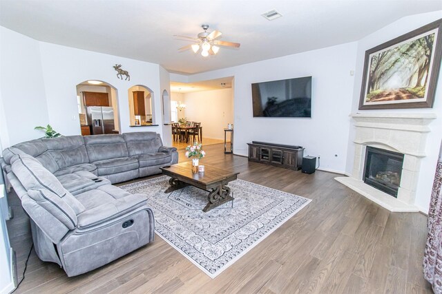 15102 Dry Ridge Ct, Humble, TX 77346 - living room featuring arched walkways, ceiling fan, wood finished floors, and a glass covered fireplace