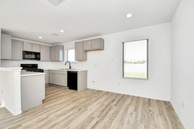 4307 Palmetto Grove Ln, Baytown, TX 77521 - kitchen with black appliances, gray cabinets, light wood-style floors, a sink, and recessed lighting