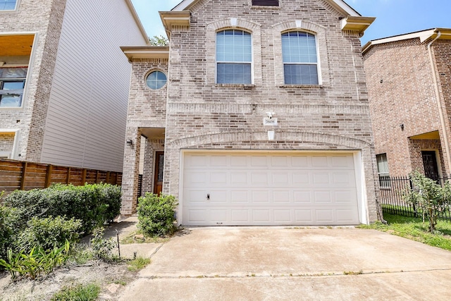 7608 Janak Dr, Houston, TX 77055 - french country style house featuring brick siding, concrete driveway, and an attached garage