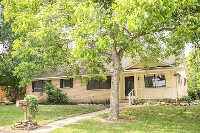 215 Edward Ln, Brenham, TX 77833 - view of front of home with brick siding, a front yard, and a shingled roof