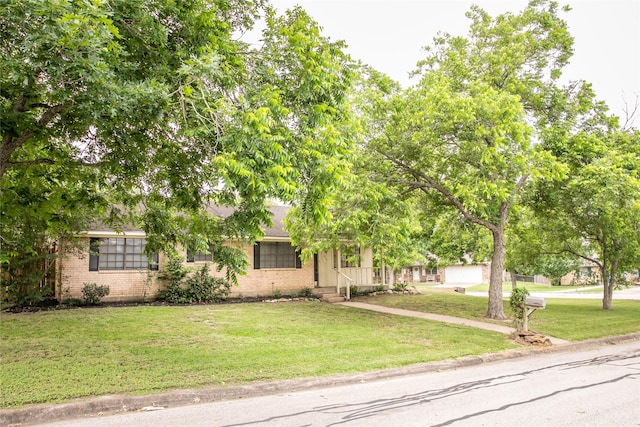 215 Edward Ln, Brenham, TX 77833 - view of property hidden behind natural elements featuring brick siding and a front lawn