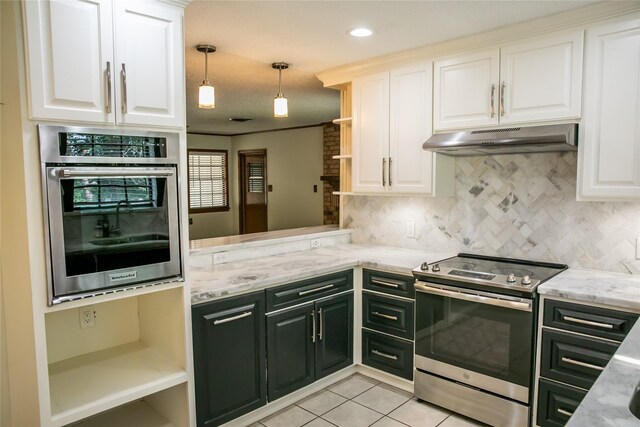 215 Edward Ln, Brenham, TX 77833 - kitchen with stainless steel appliances, open shelves, under cabinet range hood, white cabinetry, and decorative backsplash