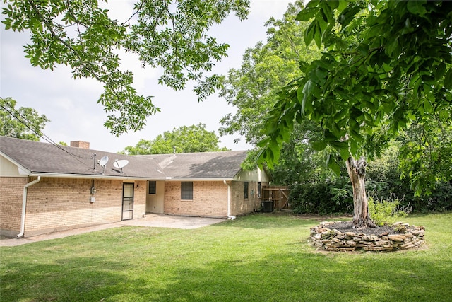 215 Edward Ln, Brenham, TX 77833 - back of house with brick siding, a patio, a chimney, and central air condition unit