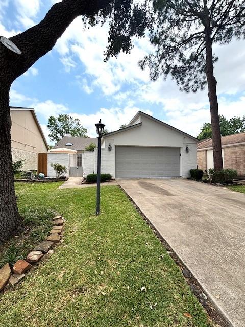 3407 S Briar Knoll Dr, Houston, TX 77082 - view of front of house with a front yard, a garage, and stucco siding