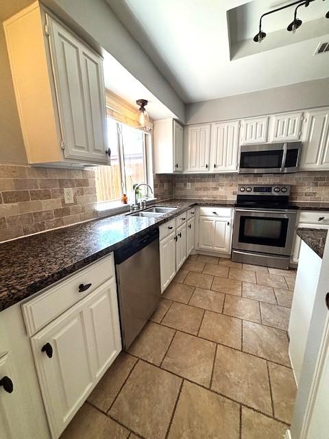 3407 S Briar Knoll Dr, Houston, TX 77082 - kitchen featuring stainless steel appliances, a sink, white cabinetry, and decorative backsplash