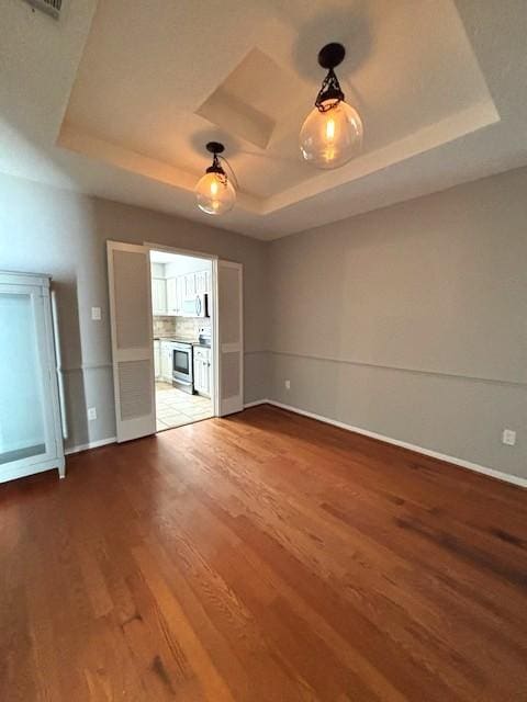 3407 S Briar Knoll Dr, Houston, TX 77082 - unfurnished room featuring a raised ceiling, light wood-style flooring, and baseboards