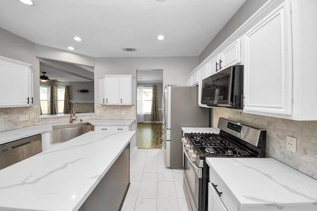 11027 Collingswood Dr, La Porte, TX 77571 - kitchen with stainless steel appliances, a sink, healthy amount of natural light, recessed lighting, and white cabinetry