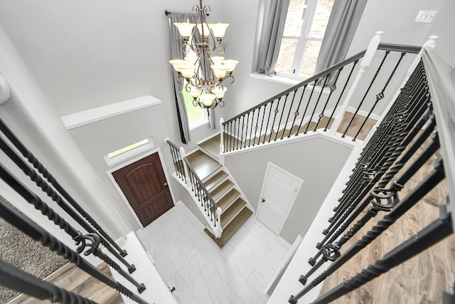 11027 Collingswood Dr, La Porte, TX 77571 - entrance foyer featuring a towering ceiling, healthy amount of natural light, a chandelier, stairs, and marble look tile flooring
