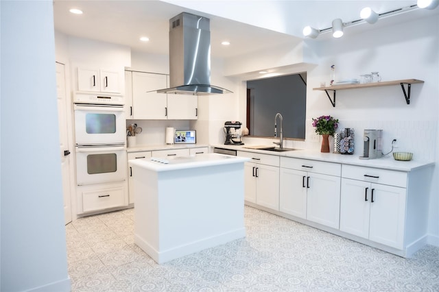 13215 Ravensway Dr, Cypress, TX 77429 - kitchen with island exhaust hood, a sink, white double oven, light countertops, and white cabinets