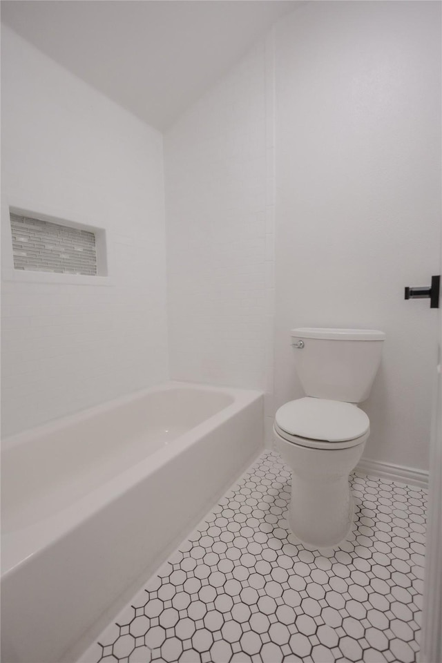 13215 Ravensway Dr, Cypress, TX 77429 - bathroom featuring toilet, a tub, and vaulted ceiling
