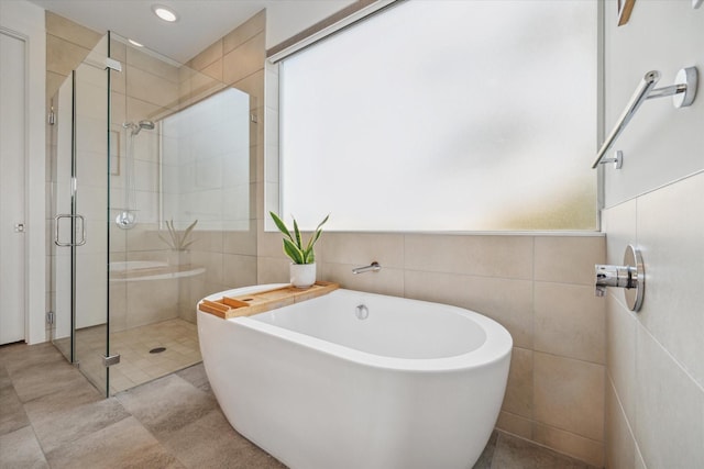 4812 Chenevert St Unit A, Houston, TX 77004 - bathroom featuring healthy amount of natural light, tile walls, a soaking tub, and a stall shower