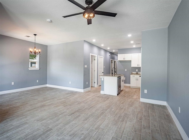 5714 Pershing St A/B, Unit A/B Houston, TX 77033 - unfurnished living room featuring ceiling fan, a chandelier, light wood-type flooring, baseboards, and recessed lighting