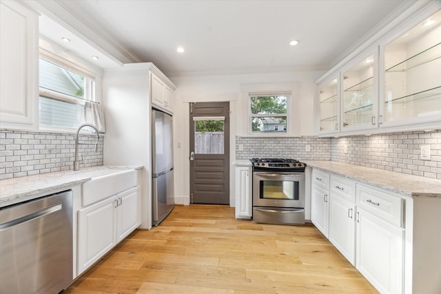 507 W 12th St, Houston, TX 77008 - kitchen with appliances with stainless steel finishes, white cabinets, tasteful backsplash, light wood finished floors, and recessed lighting