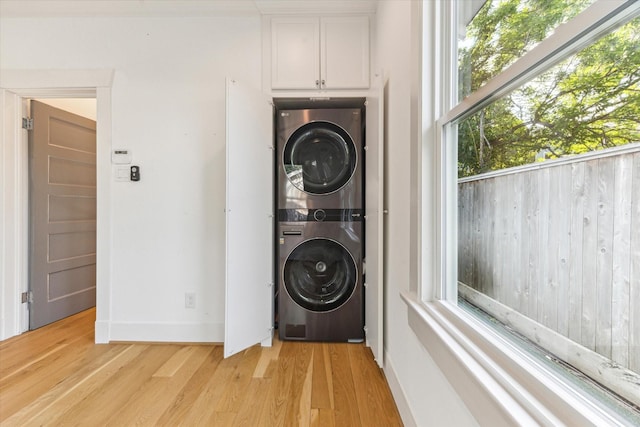 507 W 12th St, Houston, TX 77008 - laundry room with estacked washer and dryer, light wood-type flooring, and plenty of natural light