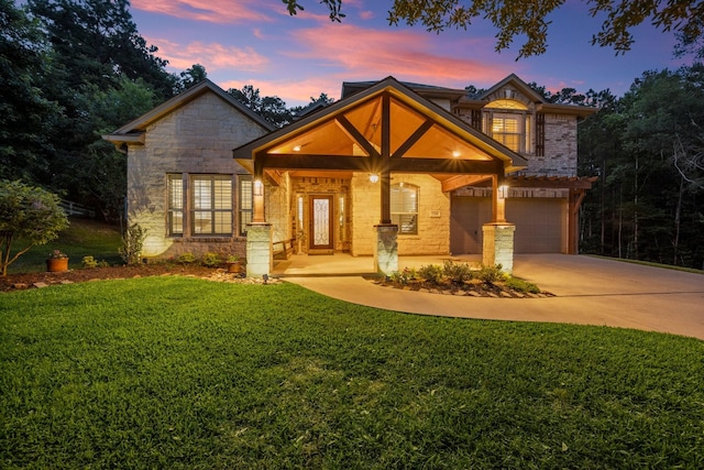 2260 Teas Crossing Dr, Conroe, TX 77304 - view of front facade with stone siding, an attached garage, driveway, and a front lawn