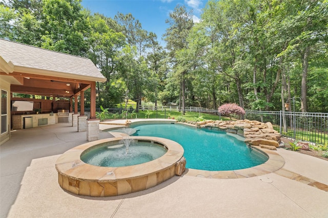 2260 Teas Crossing Dr, Conroe, TX 77304 - view of pool with an outdoor kitchen, a fenced backyard, a patio, a pool with connected hot tub, and view of wooded area
