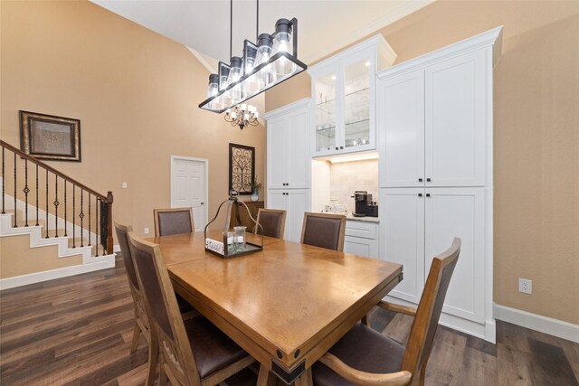 2260 Teas Crossing Dr, Conroe, TX 77304 - dining area featuring dark wood-style floors, baseboards, a chandelier, a towering ceiling, and stairs