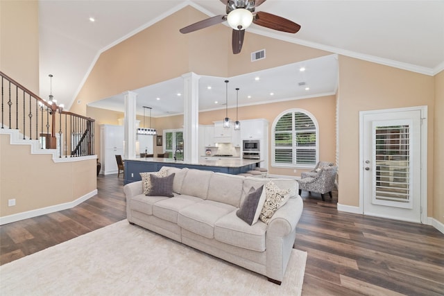 2260 Teas Crossing Dr, Conroe, TX 77304 - living room featuring dark wood-style flooring, ceiling fan, stairs, ornate columns, and baseboards