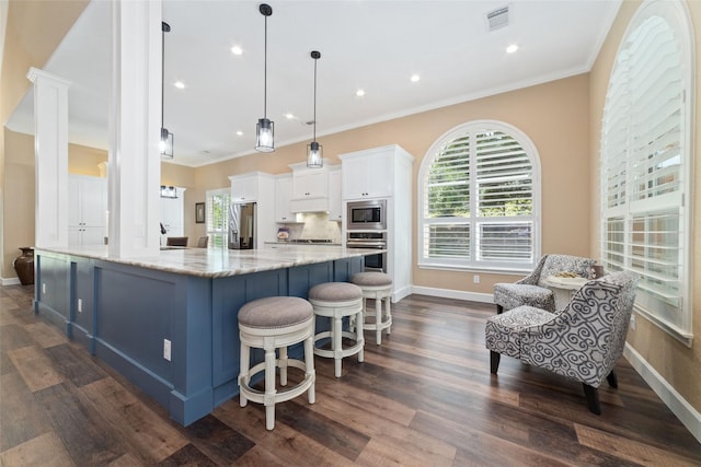 2260 Teas Crossing Dr, Conroe, TX 77304 - kitchen with stainless steel appliances, white cabinetry, plenty of natural light, crown molding, and baseboards