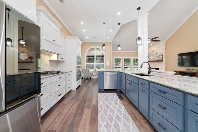 2260 Teas Crossing Dr, Conroe, TX 77304 - kitchen with stainless steel appliances, a ceiling fan, a sink, white cabinets, and vaulted ceiling